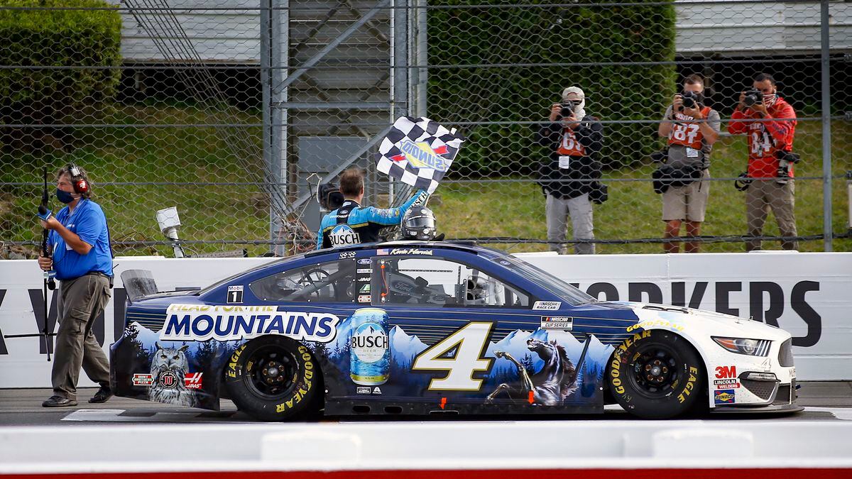 Kevin Harvick waves a checker flag for photographers after winning the NASCAR Cup Series auto race at Pocono Raceway, Saturday, June 27, 2020, in Long Pond, Pa. (AP Photo/Matt Slocum)